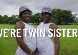 Twin sisters in white dresses and bucket hats.
