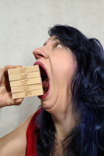 Woman with open mouth puts in Jenga blocks