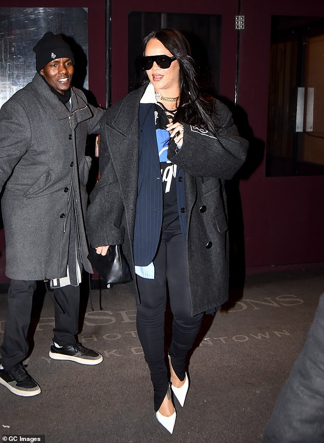 Rihanna reacts after being hit by a closing door while leaving New York hotel